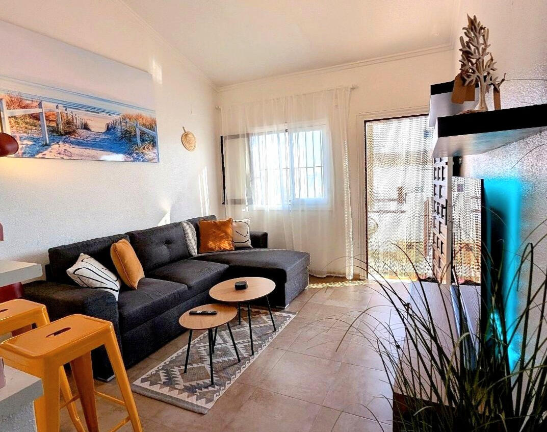 Spacious living room in Apartment Vali Torrevieja with comfortable sofa, coffee tables and access to sunny terrace