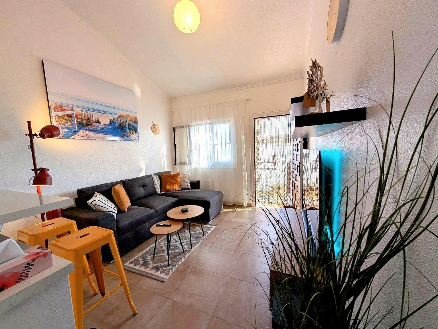 Spacious living room in Apartment Vali Torrevieja with comfortable sofa, coffee tables and access to sunny terrace